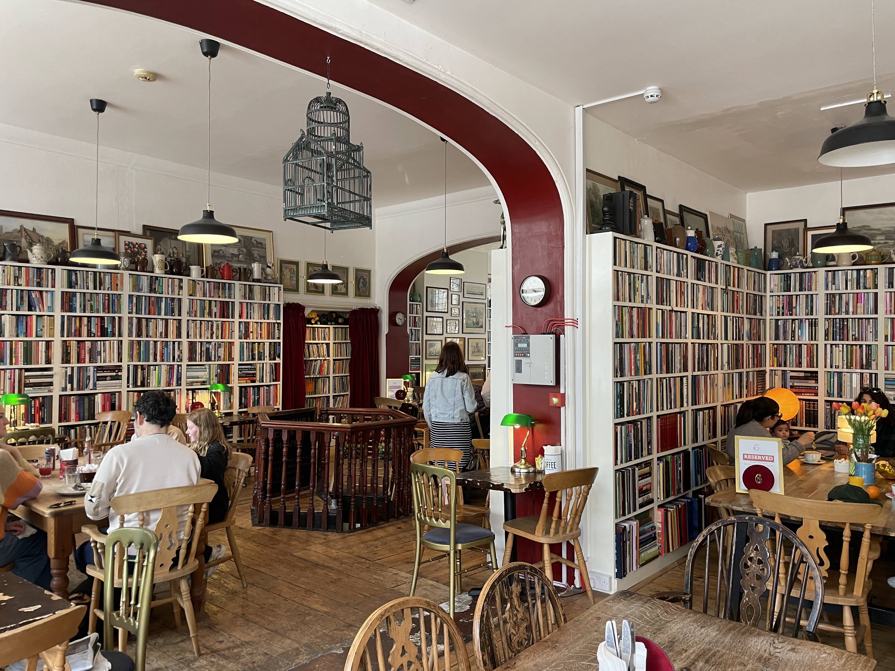 The George Street Hanushka interior with its distinctive red arch, book-lined walls, hanging lamps and wooden tables
